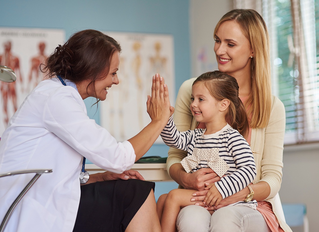 Employee Benefits - Little Girl Gives Doctor High Five at the Doctor's Office
